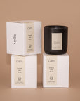 Moody shot of 3 stacked candle boxes by Vellie of the luxury candle scent Calm. Each candle is hand poured with soy & coconut wax.