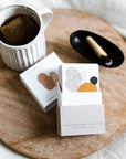 Serene setting featuring The Embodiment Deck with tea and palo santo. A peaceful atmosphere where women can set intentions and sift through the cards. Emphasizing self-awareness.