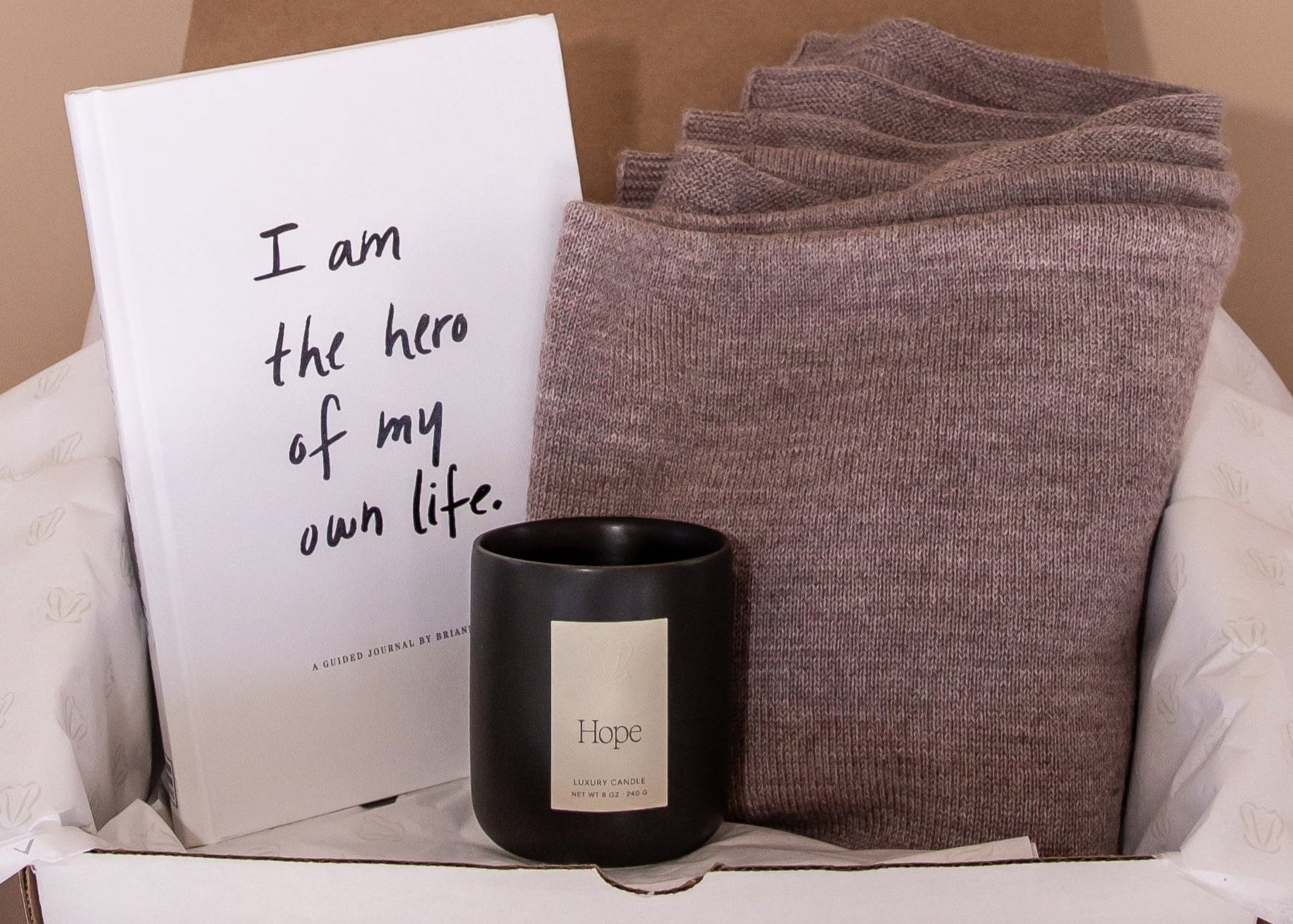 Unboxing of gift bundle by Vellie inside is the journal by Brianna Wiest, "I am the hero of my own life", a Vellie luxury candle and a Vellie baby alpaca wrap.