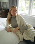 Model wears an ivory alpaca wrap ethically made in Peru. Designed to comfort and regulate your nervous system.