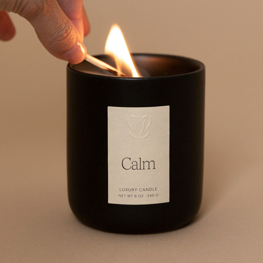 Vellie Calm Candle lit with a match, creating a soothing atmosphere with relaxing lavender and chamomile. Vegan and cruelty free made from soy and coconut wax.