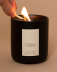 Vellie Calm Candle lit with a match, creating a soothing atmosphere with relaxing lavender and chamomile. Vegan and cruelty free made from soy and coconut wax.