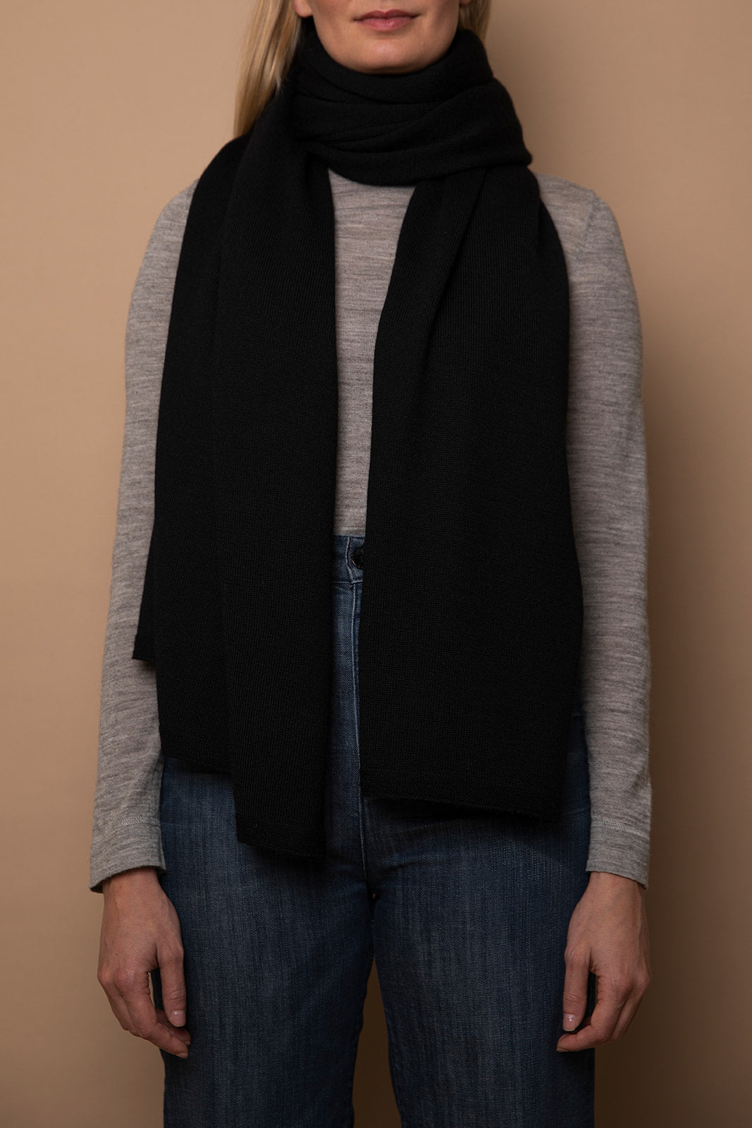 Black Vellie wrap in sustainable baby alpaca fiber, styled as a scarf, a comforting hug for those in need of warmth and emotional support during difficult life moments.