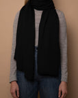Black Vellie wrap in sustainable baby alpaca fiber, styled as a scarf, a comforting hug for those in need of warmth and emotional support during difficult life moments.