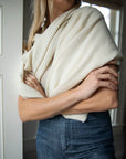 Ivory Vellie wrap styled around the torso for a chic, elegant look, showcasing its versatility and luxurious 100% fair-trade baby alpaca fiber. Perfect for adding a touch of warmth and style to any outfit.