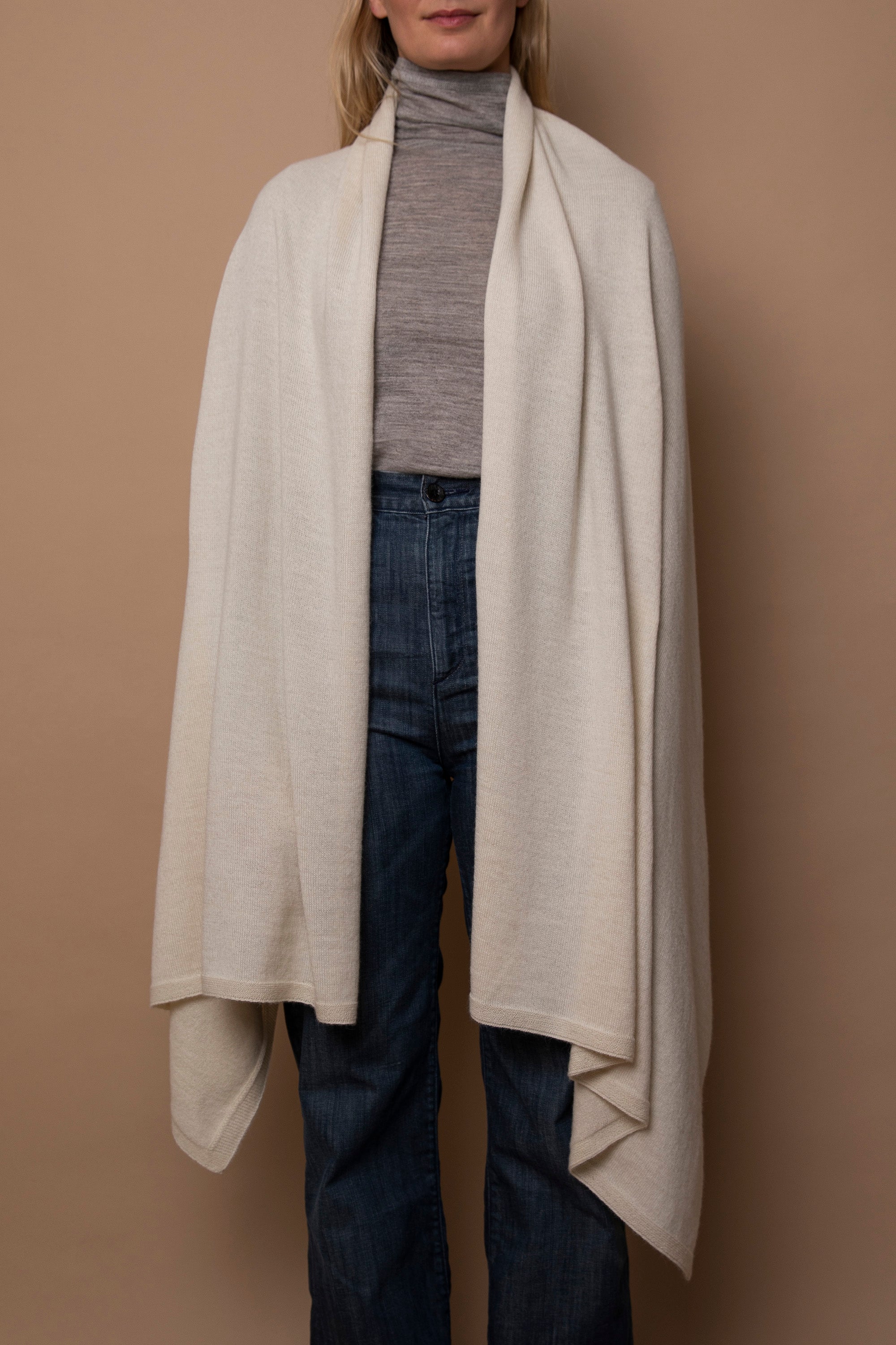 Ivory Vellie wrap worn naturally, showcasing its luxurious 100% fair-trade baby alpaca fiber, offering warmth, softness, and timeless elegance.