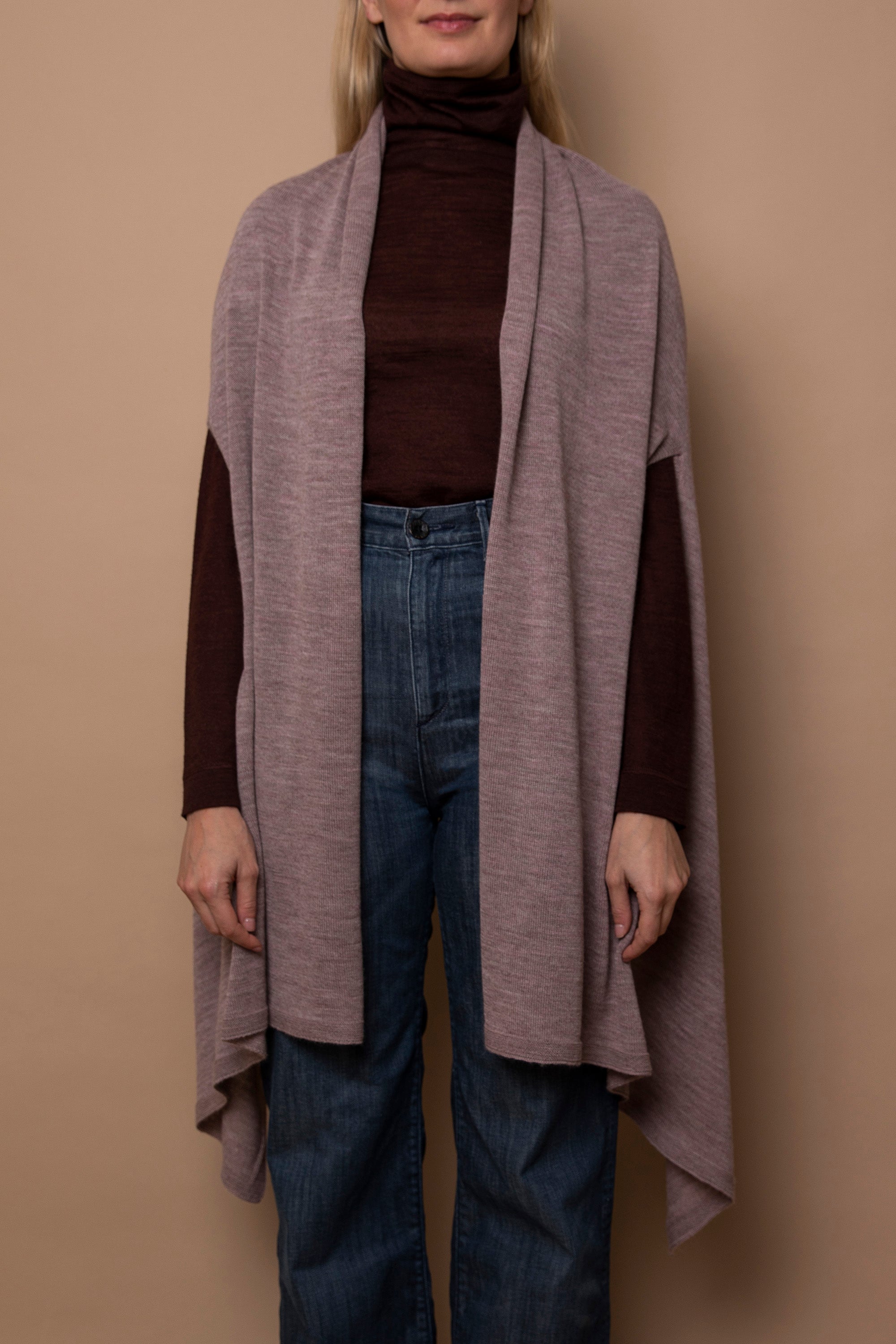 Mauve Vellie wrap worn with arms through armholes showcasing its luxurious 100% fair-trade baby alpaca fiber, an heirloom quality piece known for it’s exceptional warmth and timelessness.