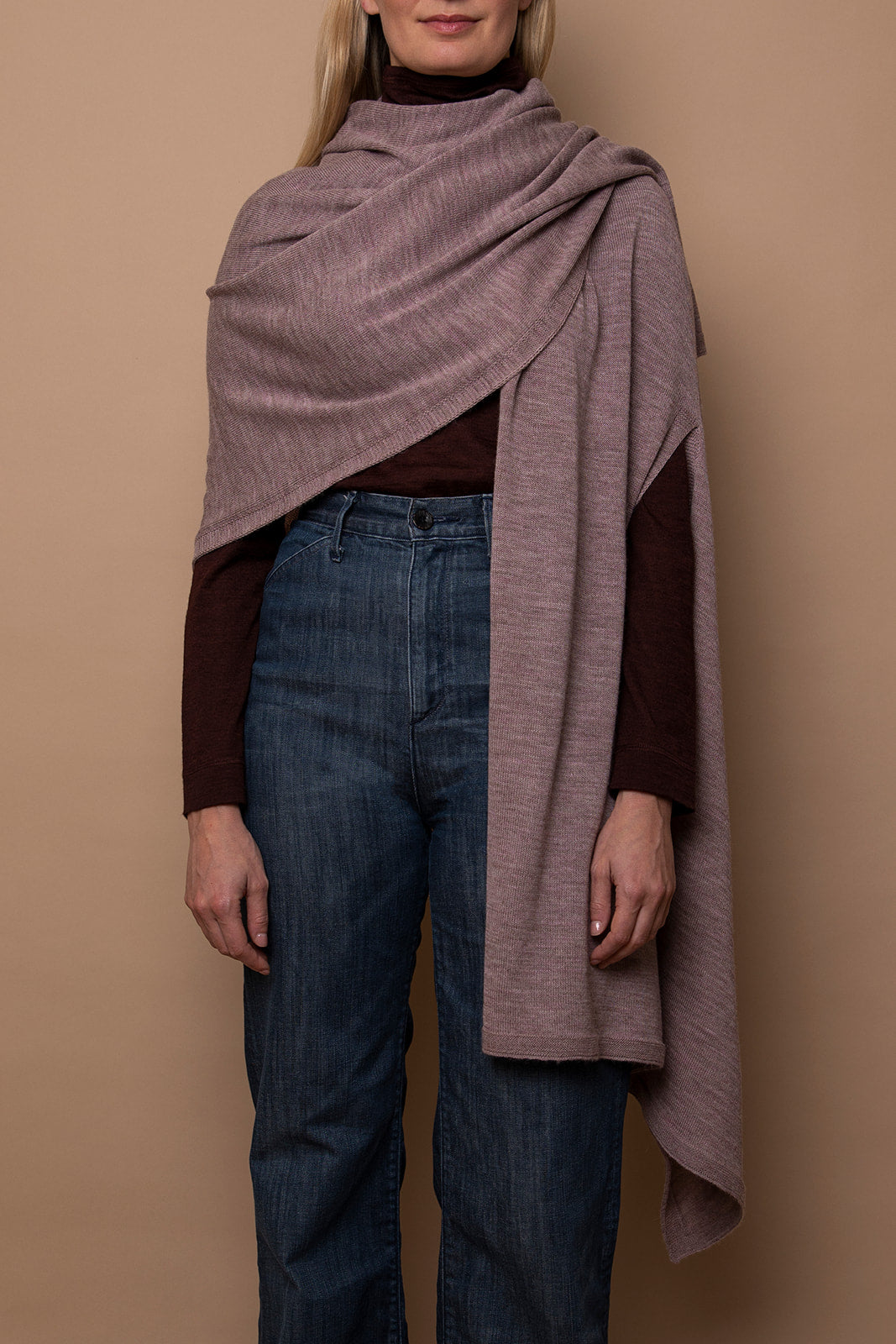 Mauve Vellie wrap draped over one shoulder, made from hypoallergenic, antimicrobial baby alpaca fiber—luxurious, durable, and low-maintenance. Color is soft Mauve, almost lavender.