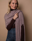 Model wearing a mauve colored wrap. Made from 100% fair-trade baby alpaca fiber. Draped over one shoulder, ethically crafted from 100% fair-trade baby alpaca fiber.