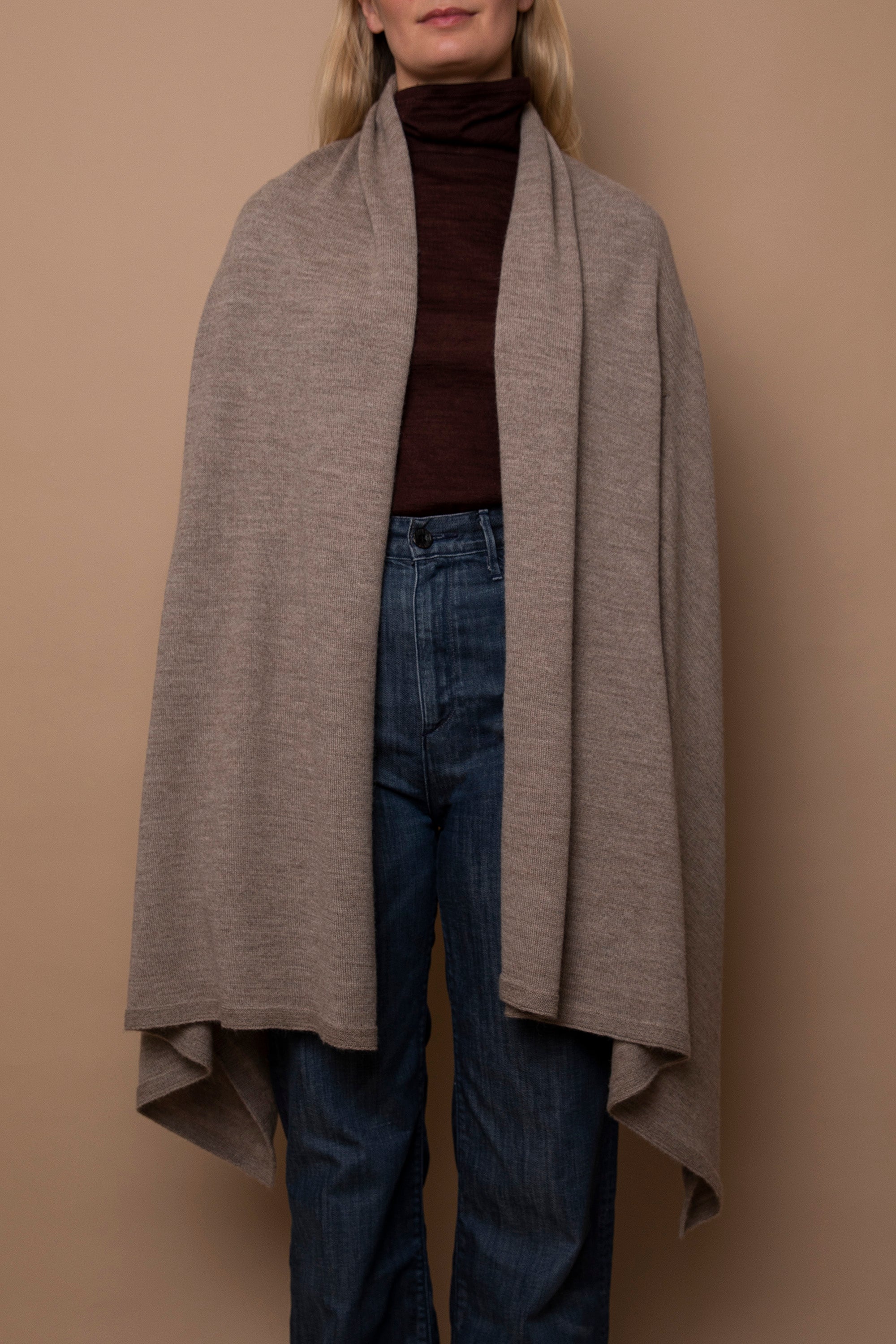 Oat Vellie wrap worn naturally, draping gracefully for an effortlessly elegant look, made from 100% fair-trade baby alpaca fiber.
