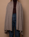 Oat Vellie wrap worn naturally, draping gracefully for an effortlessly elegant look, made from 100% fair-trade baby alpaca fiber.
