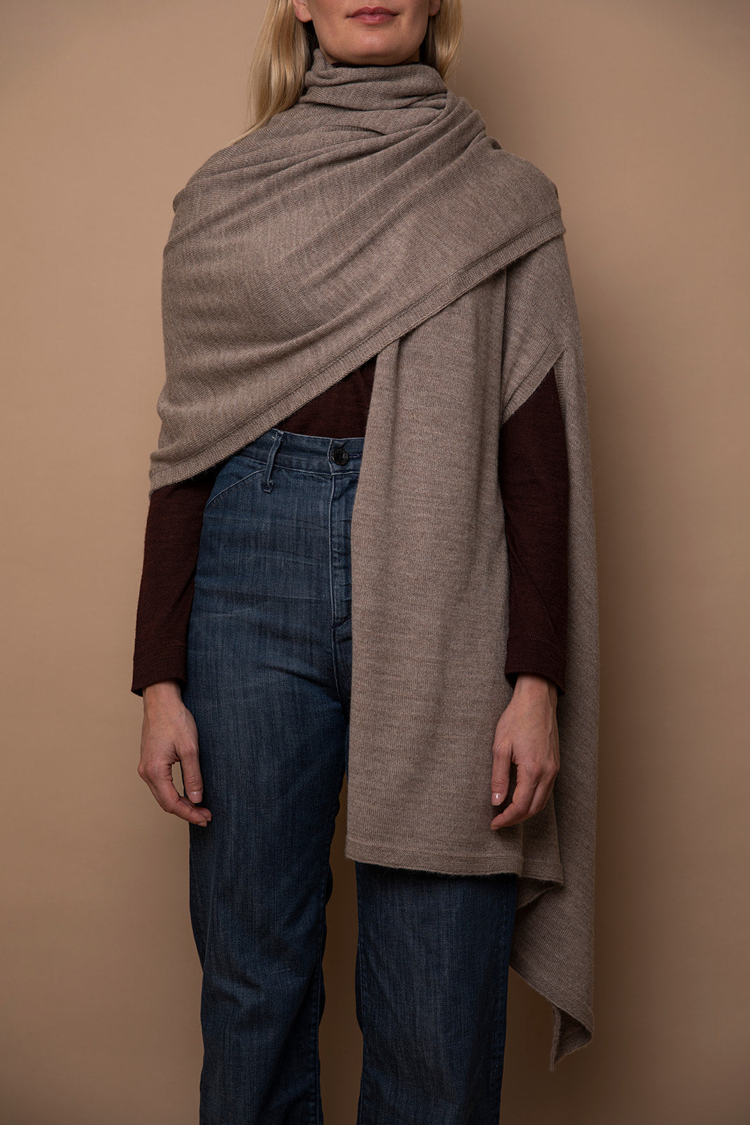 Oat Vellie wrap draped over one shoulder, highlighting its timeless elegance and warmth, made from hypoallergenic, antimicrobial baby alpaca fiber.
