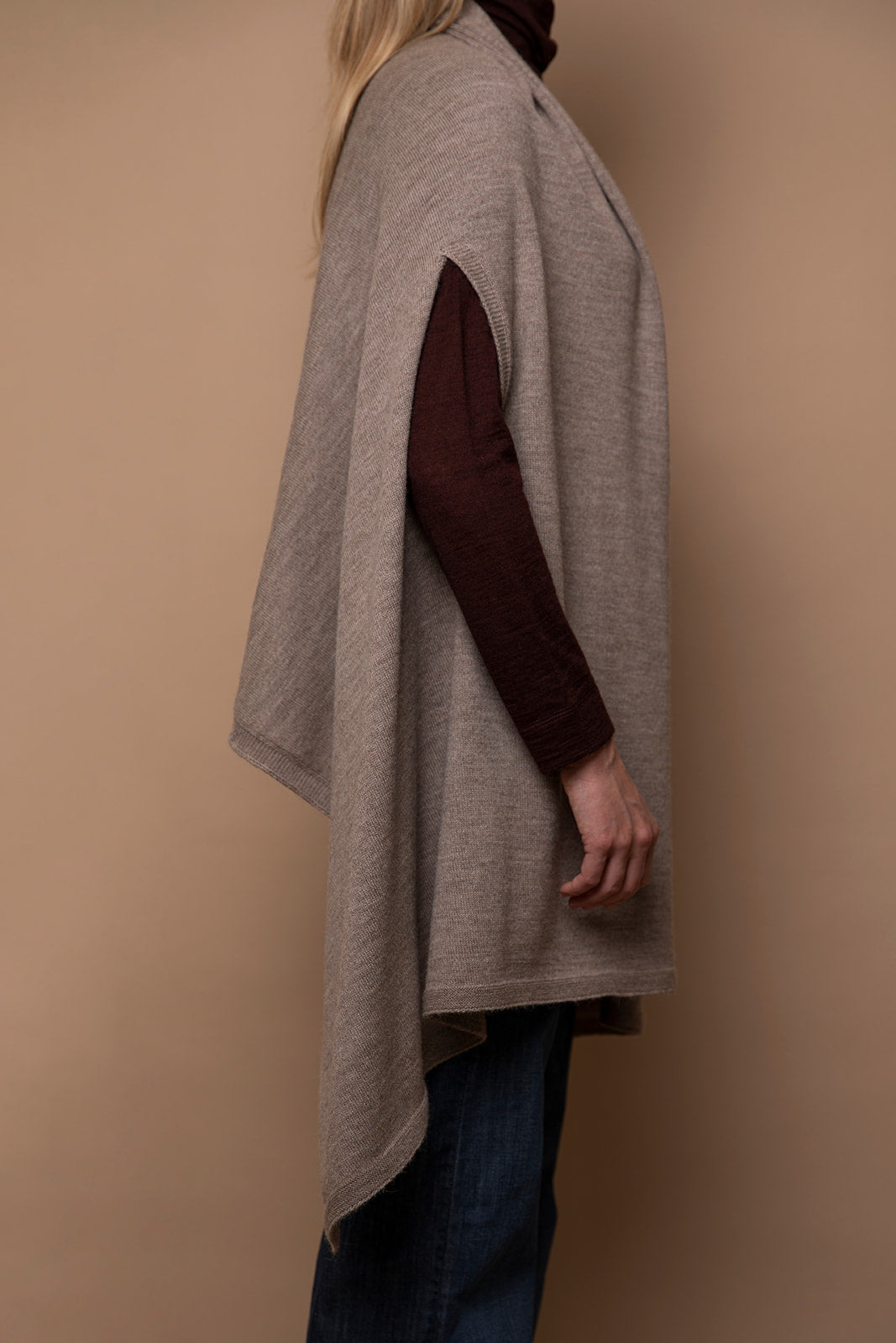 Side view of oat Vellie wrap with arm through armhole, highlighting its sleek design and luxurious feel, crafted from hypoallergenic, antimicrobial baby alpaca fiber.