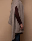 Side view of oat Vellie wrap with arm through armhole, highlighting its sleek design and luxurious feel, crafted from hypoallergenic, antimicrobial baby alpaca fiber.