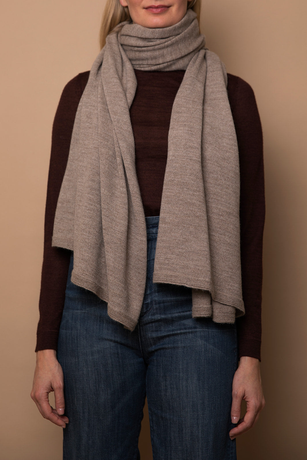 Oat Vellie wrap styled as a scarf, offering cozy warmth and sustainable elegance, made from 100% fair-trade baby alpaca fiber for a chic, versatile look.