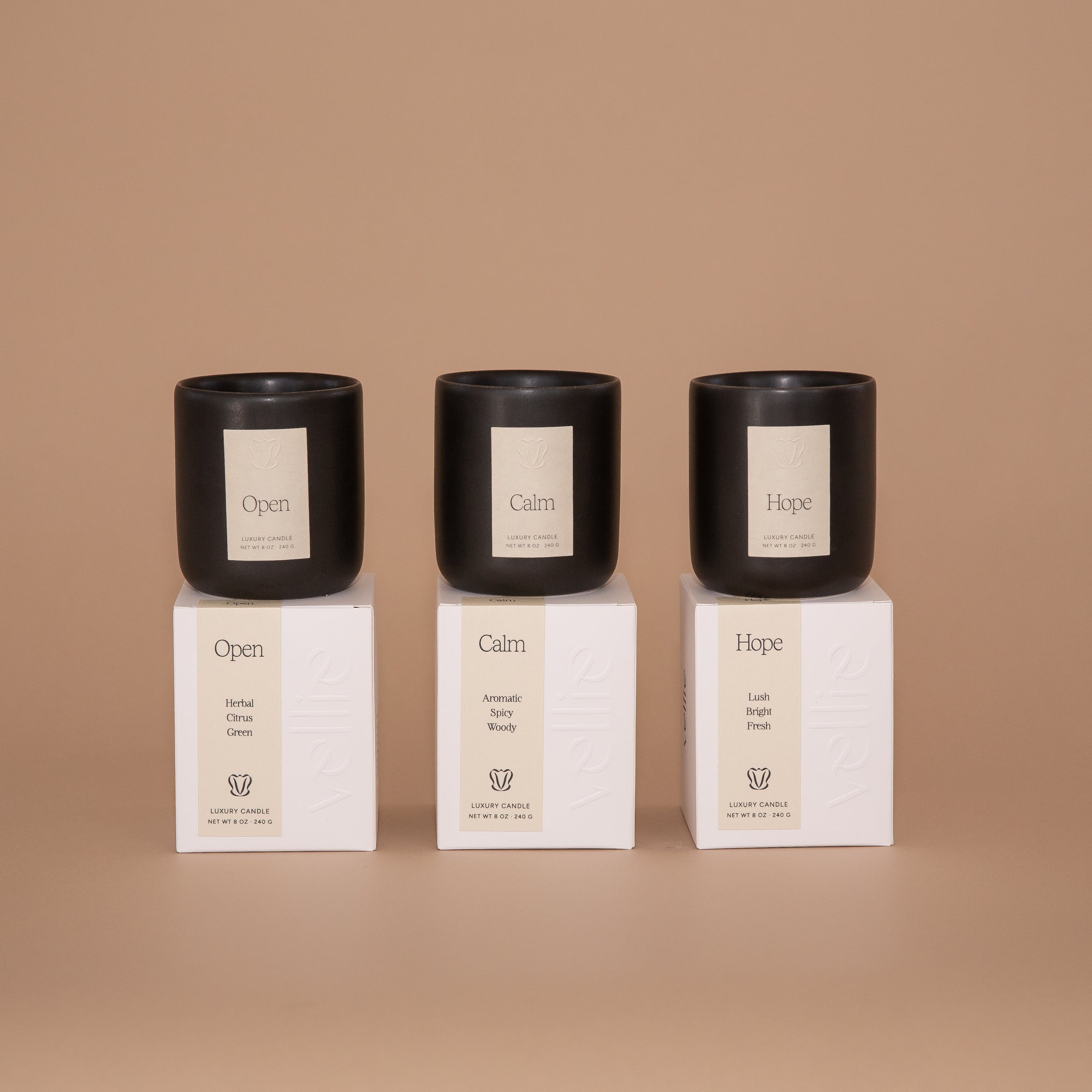 3 candles dispayed on top of packaged boxes. Left to right: Open, Calm and Hope scents by Vellie. Hand-poured with soy & coconut wax. Vegan & cruelty-free.