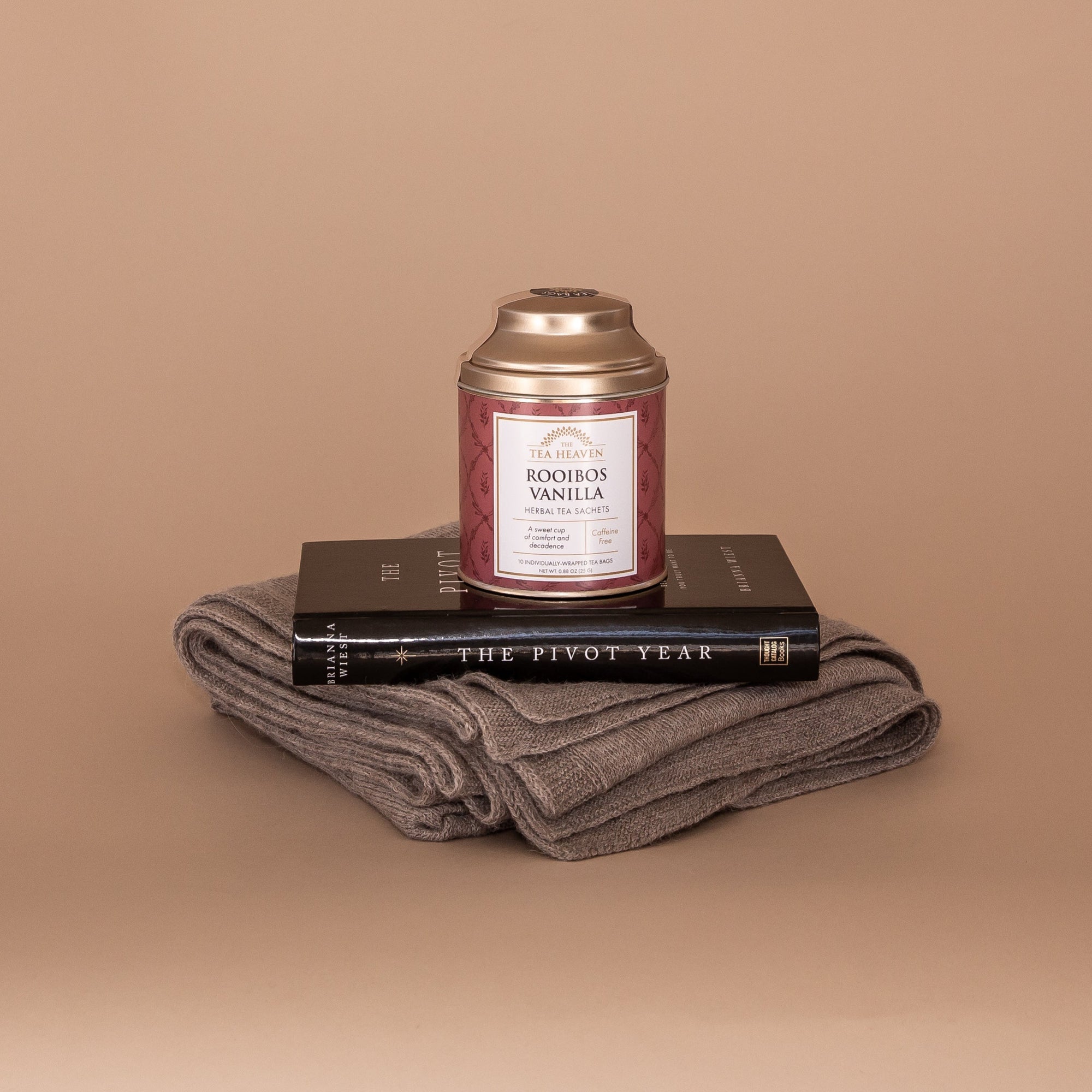 I'll Stand By You Gift Bundle. Displayed here stacked: folded Vellie Wrap made from sustainably sourced baby alpaca, The Pivot Year paperback by Brianna Wiest and Rooibos Vanilla Tea by Tea Heaven.