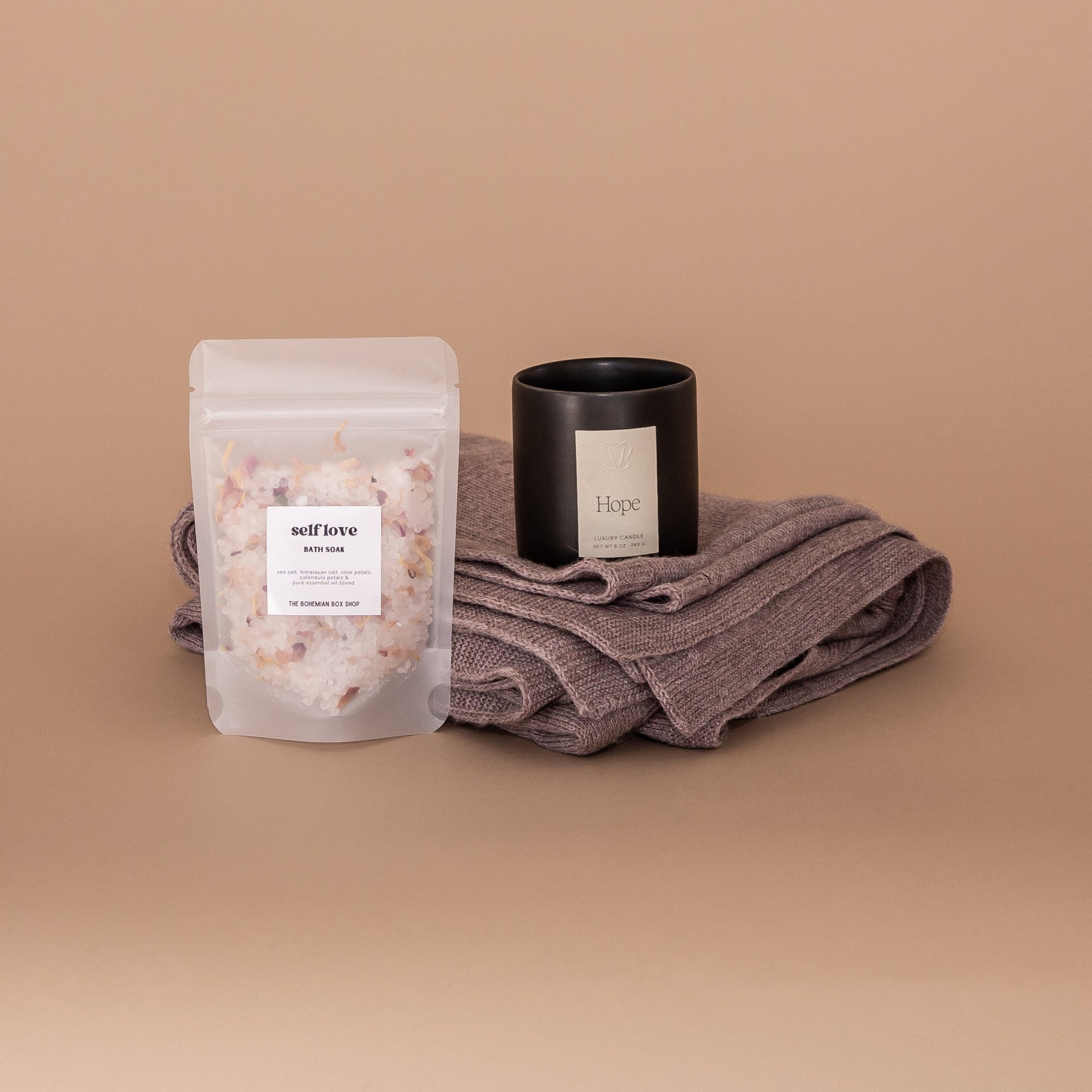 Imagine Gift Set. A Gift Bundle curated from women owned brands. Seen here, Self-Love bath salts, luxury Vellie Candle in the scent Hope and a Vellie wrap folded.
