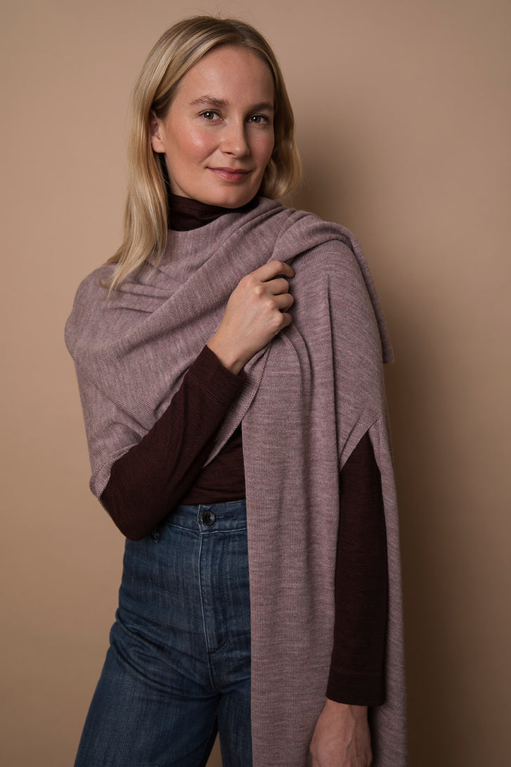Model wearing a mauve colored wrap. Made from 100% fair-trade baby alpaca fiber. Draped over one shoulder, ethically crafted from 100% fair-trade baby alpaca fiber.